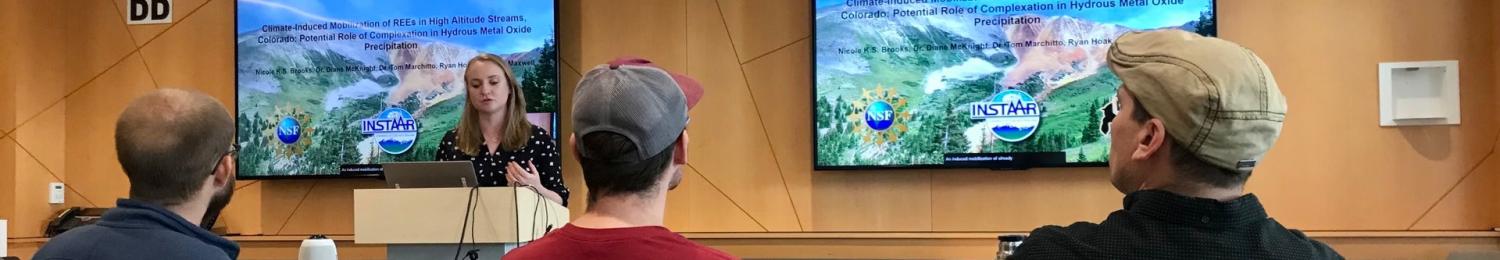 Three audience members watch a speaker at the INSTAAR Monday seminar