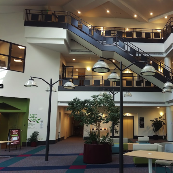 Three story open atrium at the north end of SEEC building with small trees, staircases, and open balconies. Photo by Peter Condit.