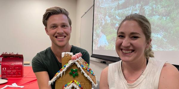 Two people at the JEDI social event work on their gingerbread houses