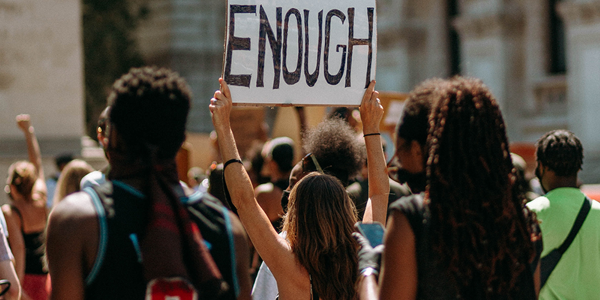 Back view of a group of protestors with a sign saying "enough" (Liam Edwards)