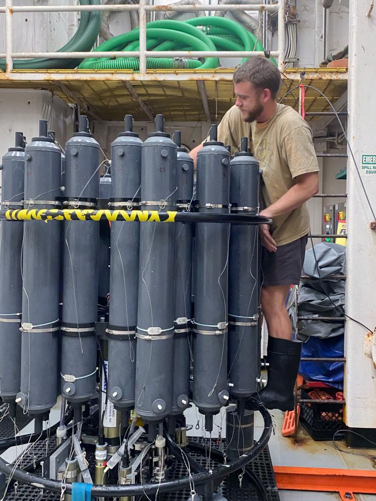 Samuel Mogen works on a rosette water sampler during a research cruise