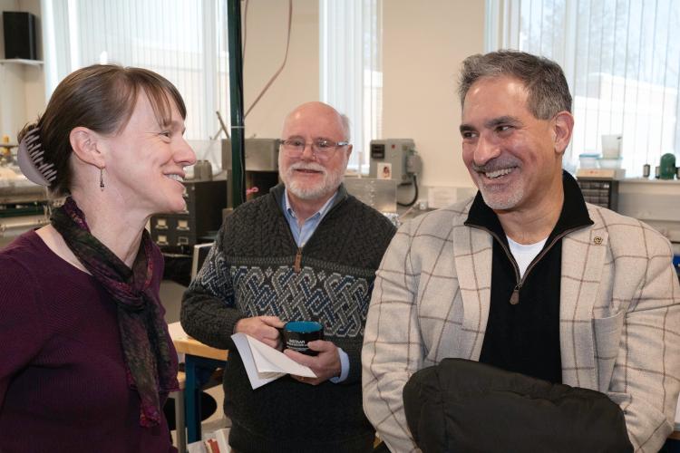 Three people chat in a science lab