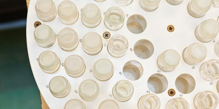 Multiple lab vials held on a grid await measurement