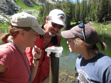 Megan Otu (former INSTAAR postdoc), Alex Wolfe and Heather Mosher examine the sediment water interface of a gravity core from a high elevation lake. 