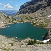 A view of from above of Sky Pond in Rocky Mountain National Park.  Look carefully and you'll see researchers in a small inflatable boat, taking lake measurements and samples.