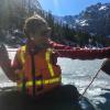 Bella Oleksy works from an inflatable boat on a partly frozen mountain lake