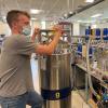 Researcher works in a stable isotope lab that contains lots of blue and beige gas flasks