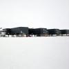 The American buildings of the Amundsen-Scott South Pole Station are stark black boxes on a white snowy ground. Photo by Vicki Beaver/Alamy.