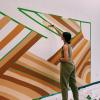 Maddie Sanders, one of the CASE Fellows, works on a large mural