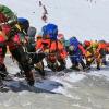 Climbers in a dense line walk up a slope on Mt Everest. Up to 60,000 tourists visit the National Park each year.