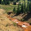 Water exiting a mountain mine, with rust colored streambed