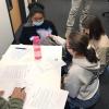 Four 8th graders touching, smelling, and learning about permafrost.