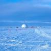 A faceted white dome, home to the drilling rig of a coring expedition, sits atop the Greenland ice sheet. Photo by Christine Massey, University of Vermont.