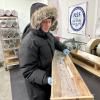 Valerie Morris, in puffy fur-lined parka, carries a section of the GISP2 ice core in a wooden tray at the NSF Ice Core Facility.
