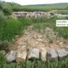 A landscape restoration project in a grassy gully on Colorado's Western Slope. Adding rocky protection and planting native grasses and shrubs has increased plant growth, trapped storm sediment, and increased soil storage.