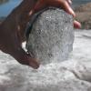 A hand holds a block of melting ice taken from an ice core of a snowfield