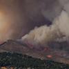 The Calwood fire burns through grass and trees along a ridge, releasing a large smoke plume