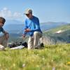 A student and Prof. Bill Bowman crouch on the wildflower-strewn tundra of the Mountain Research Station.