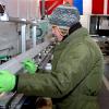 A science technician measures a section of an Antarctic ice core as it begins its journey down a core processing line. Scientists and technicians will cut the ice so it can be sent to labs around the country for analysis. | Credit: Peter Rejcek, NSF