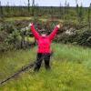 Carolyn Gibson stands in the middle of a collapse scar representing wet, degrading permafrost in the Arctic