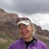 Suzanne Anderson stands outside with mountains in the background.