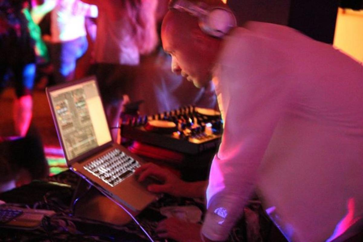 DJ in a colorful lighted room playing music