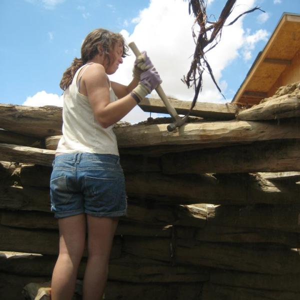 Student works on the roof of a dilapidated building