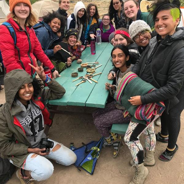 Students pose with spoons around picnic table 
