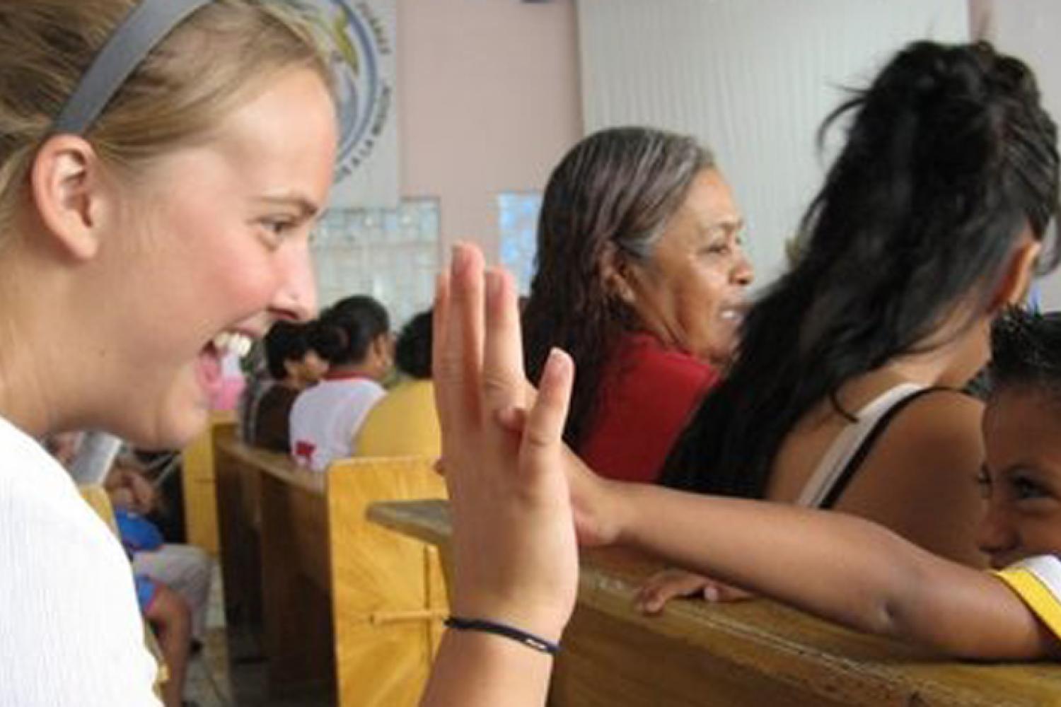 Student high-fiving a child at a church