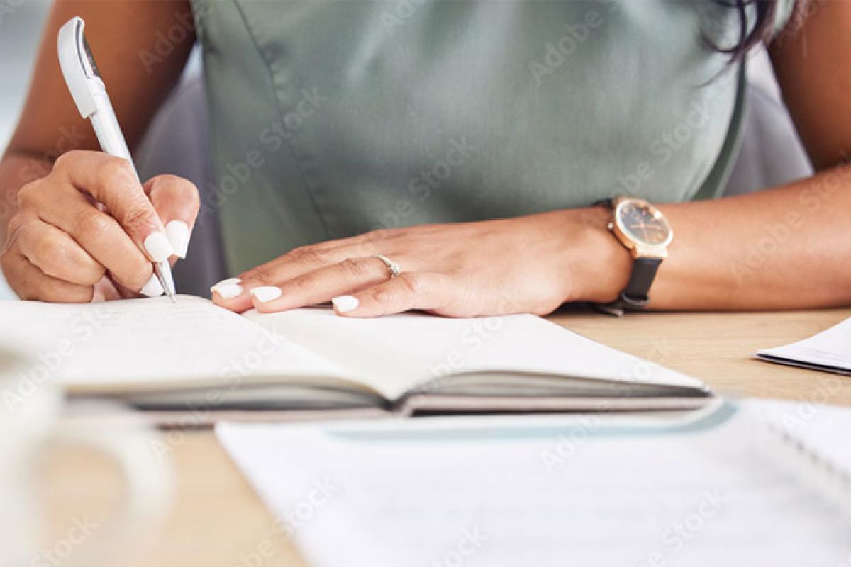 hands writing in notebook