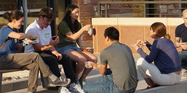 Group of students eating together outdoors