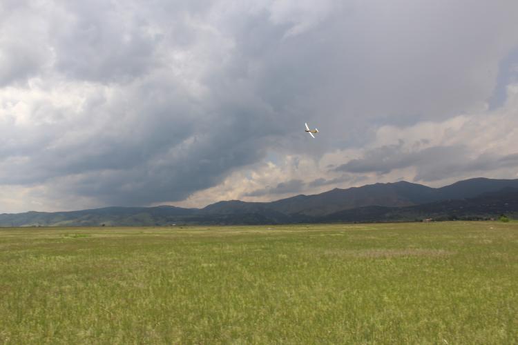 Unmanned aircraft flying in as storm clouds gather over the foothills.