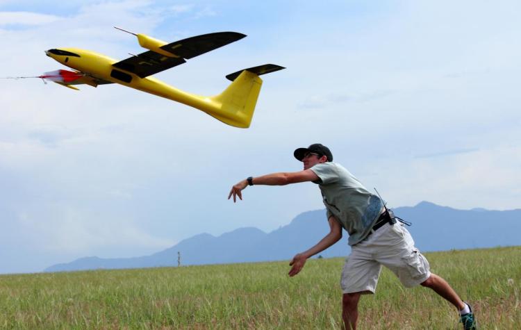 Student propelling a drone into the air.