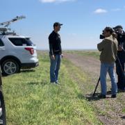 A team member talking to media in the field 