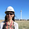 A woman standing with wind turbines in back