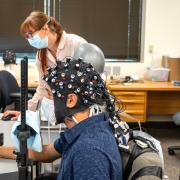CU Boulder postdoctoral researcher Rosy Southwell and undergraduate student Cooper Steputis demonstrate the use of a functional near-infrared spectroscopy device