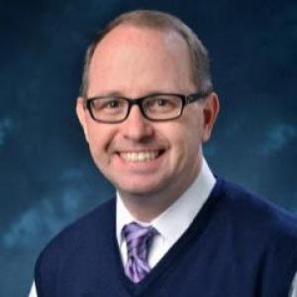 Paul Goodrum portrait on a blue background 