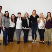 Students and faculty standing next to a wall in a posed photo