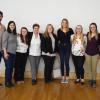 Students and faculty standing next to a wall in a posed photo