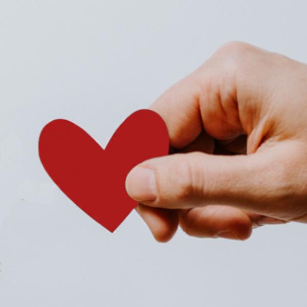 Photo of a hand holding a paper heart