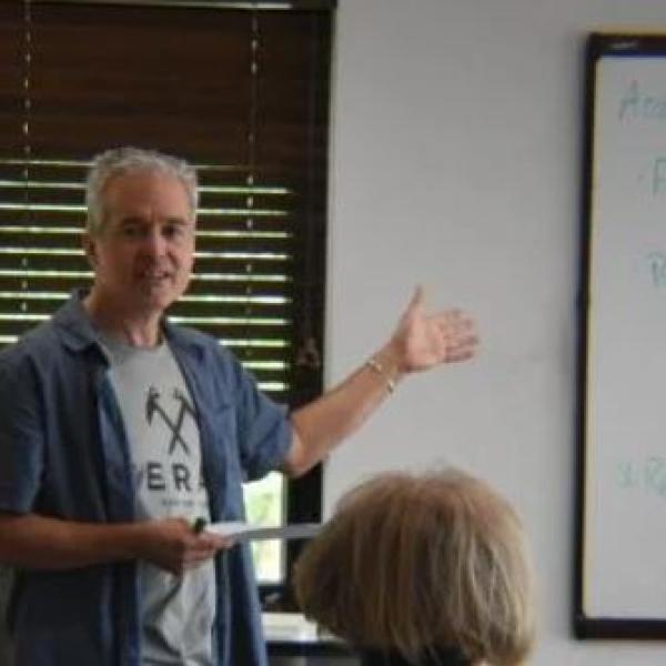 Photo of instructor teaching in front of a white board