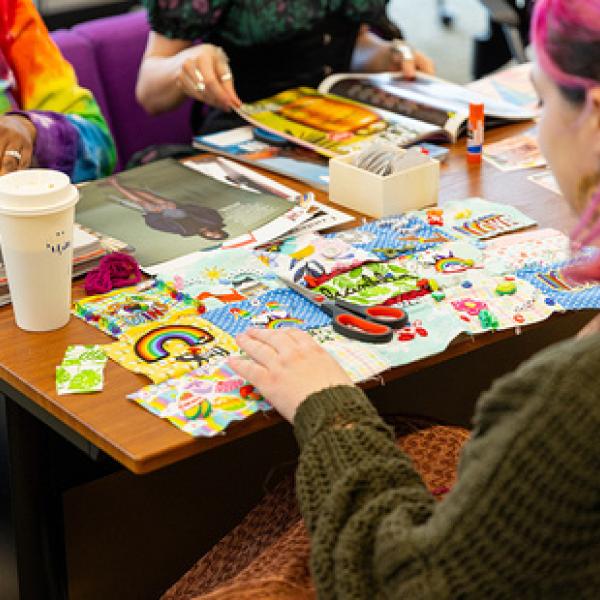 Photo of students making a quilt and looking at magazines