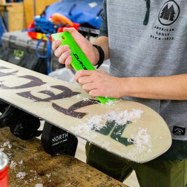 Photo of person tuning a snowboard