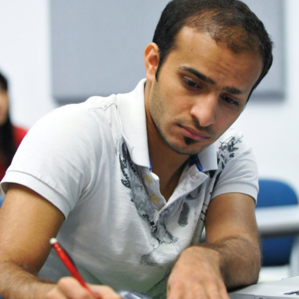 IEC Student writing in notebook in classroom