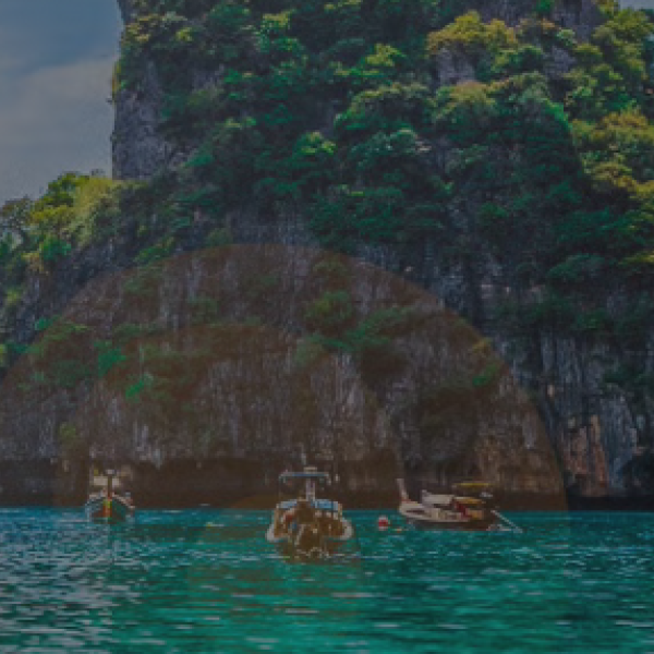 Ocean with three boats and island in the background