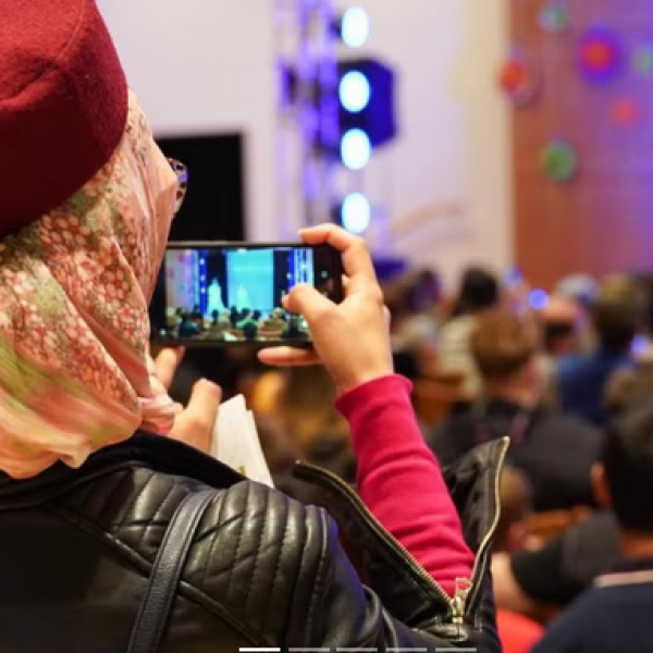 Person filming performers on stage at the International Festival
