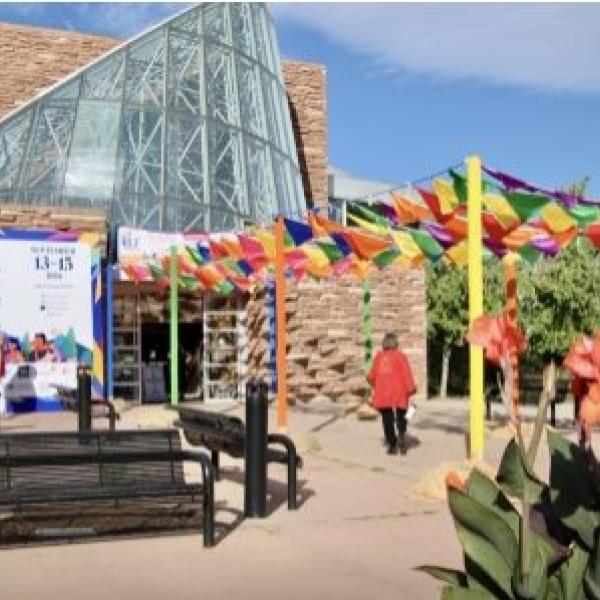 Front of Boulder Public Library deocrated with colorful falgs and JLF sign