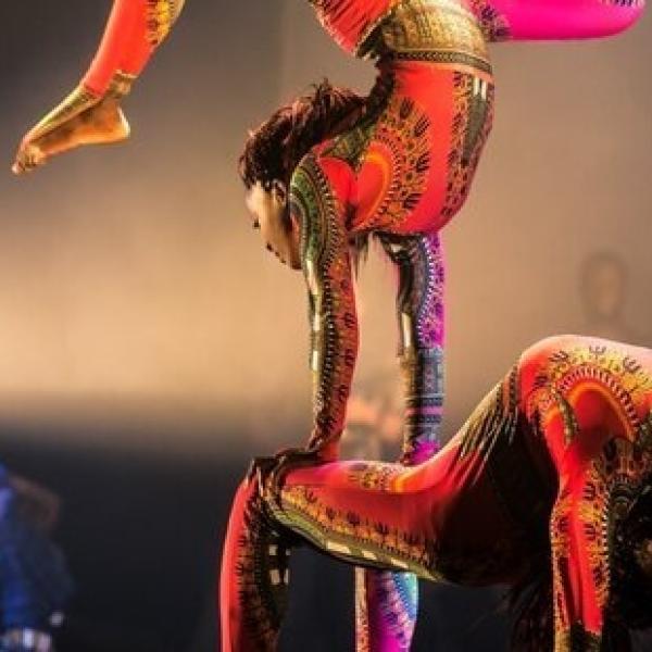 Two performers from Cirque Kalabante: Afrique en Cirque with one personperforming an acrobat move stacked on top of another performer