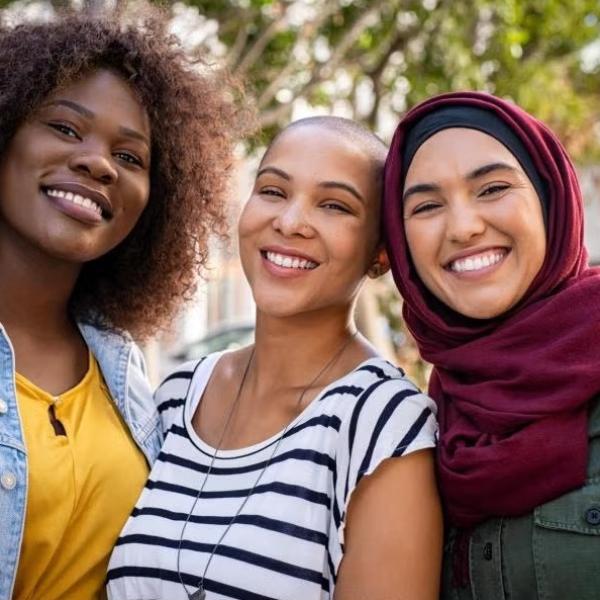 Three students standing together smiling