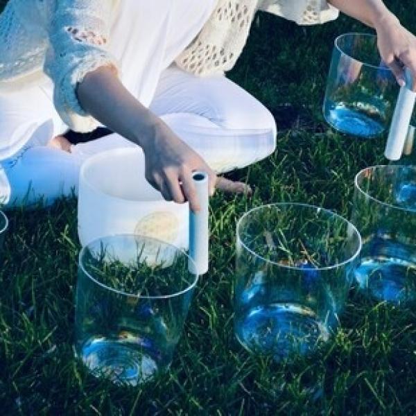 Person playing a series of singing bowls